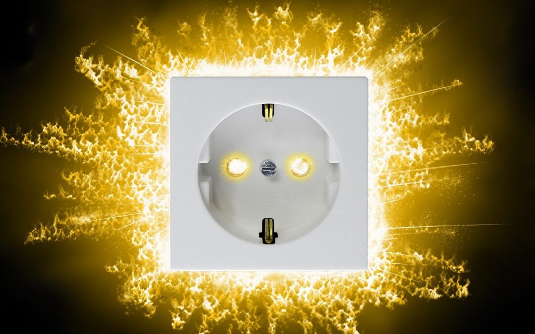 En esta imagen vemos un enchufe donde por detras se ve rayos de electricidad para destacar el peligro de una sobrecarga eléctrica